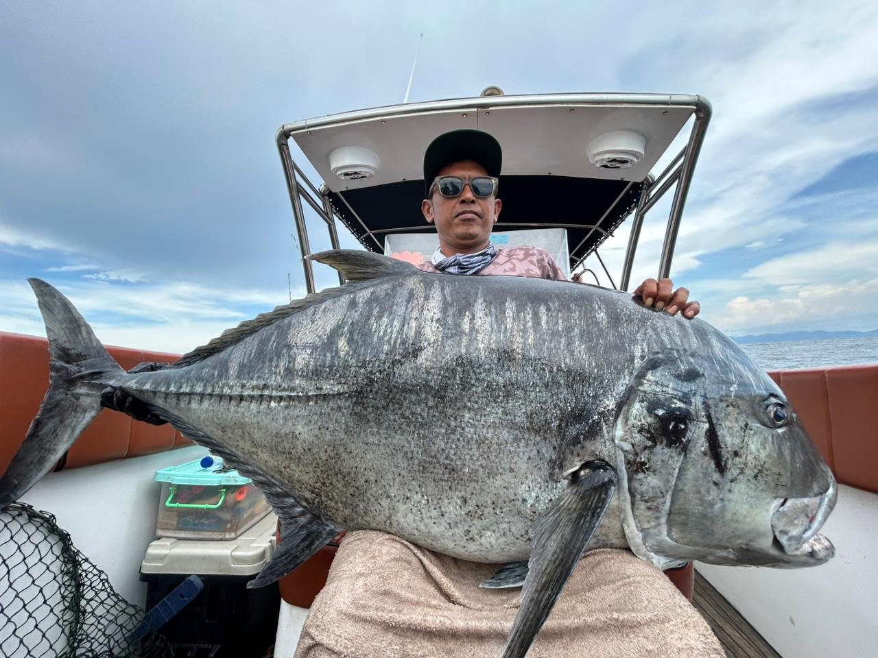 Angler holding giant amberjack during fishing trip in Nusa Penida